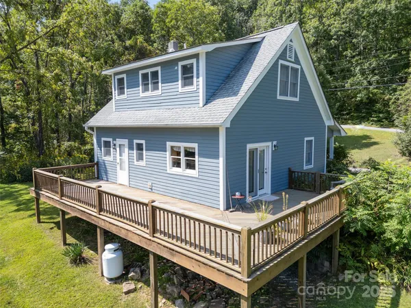 a view of a house with wooden deck and furniture