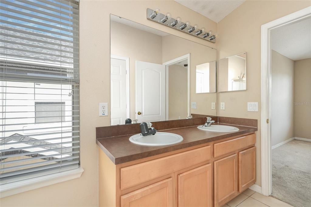 6686 South Goldenrod Road, Unit 139A Orlando, FL 32822 - Photo 15 of 23 a bathroom with a granite countertop sink and a mirror