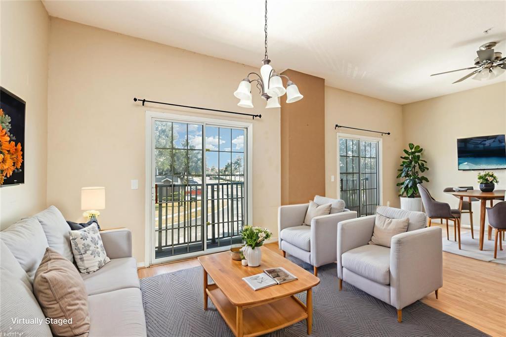 6686 South Goldenrod Road, Unit 139A Orlando, FL 32822 - Photo 5 of 23 a living room with furniture a chandelier and a flat screen tv