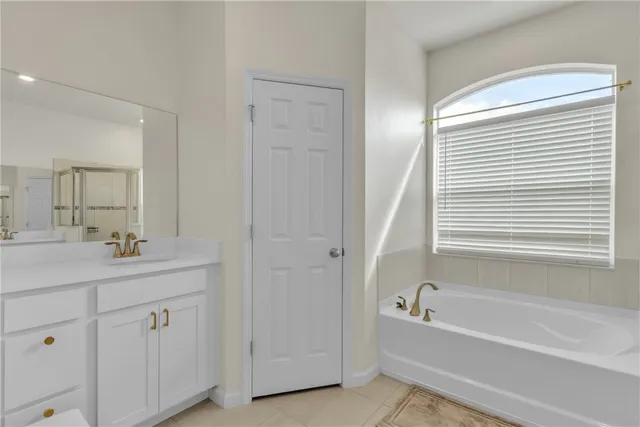a bathroom with a tub a sink and a window