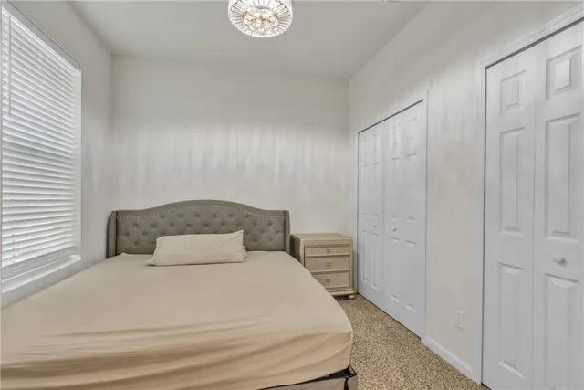 a bedroom with a bed and painting on the wall