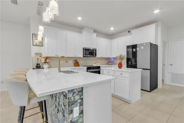 a kitchen with stainless steel appliances a refrigerator sink and microwave