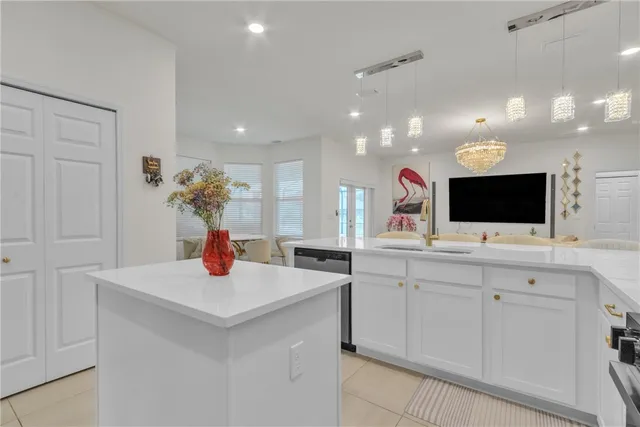 a kitchen with stainless steel appliances kitchen island a sink and a flat screen tv
