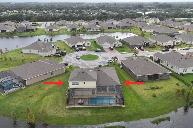 an aerial view of residential houses with outdoor space and parking