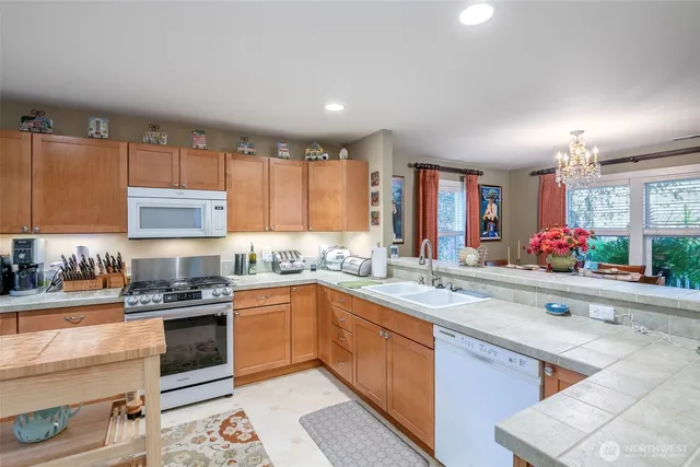 a kitchen with stainless steel appliances granite countertop a sink stove and cabinets