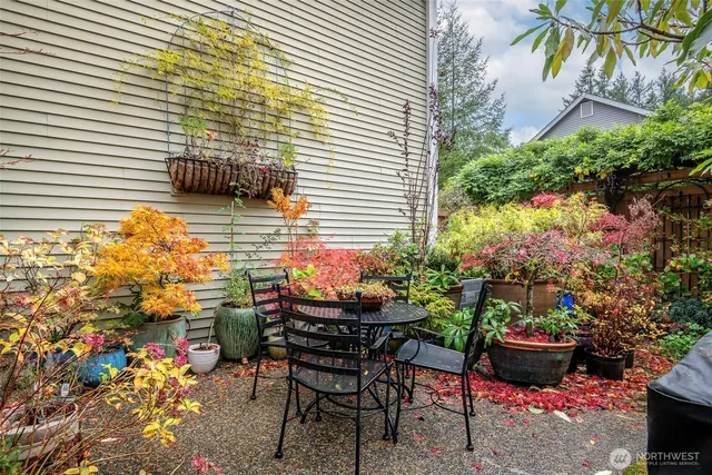 a backyard of a house with table and chairs and potted plants