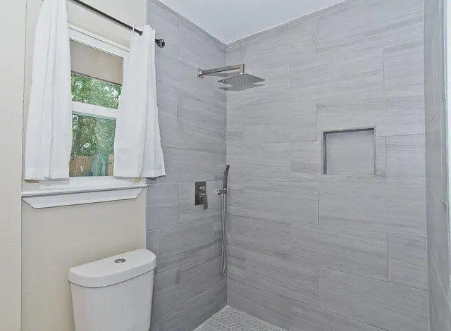 a bathroom with a toilet and a shower