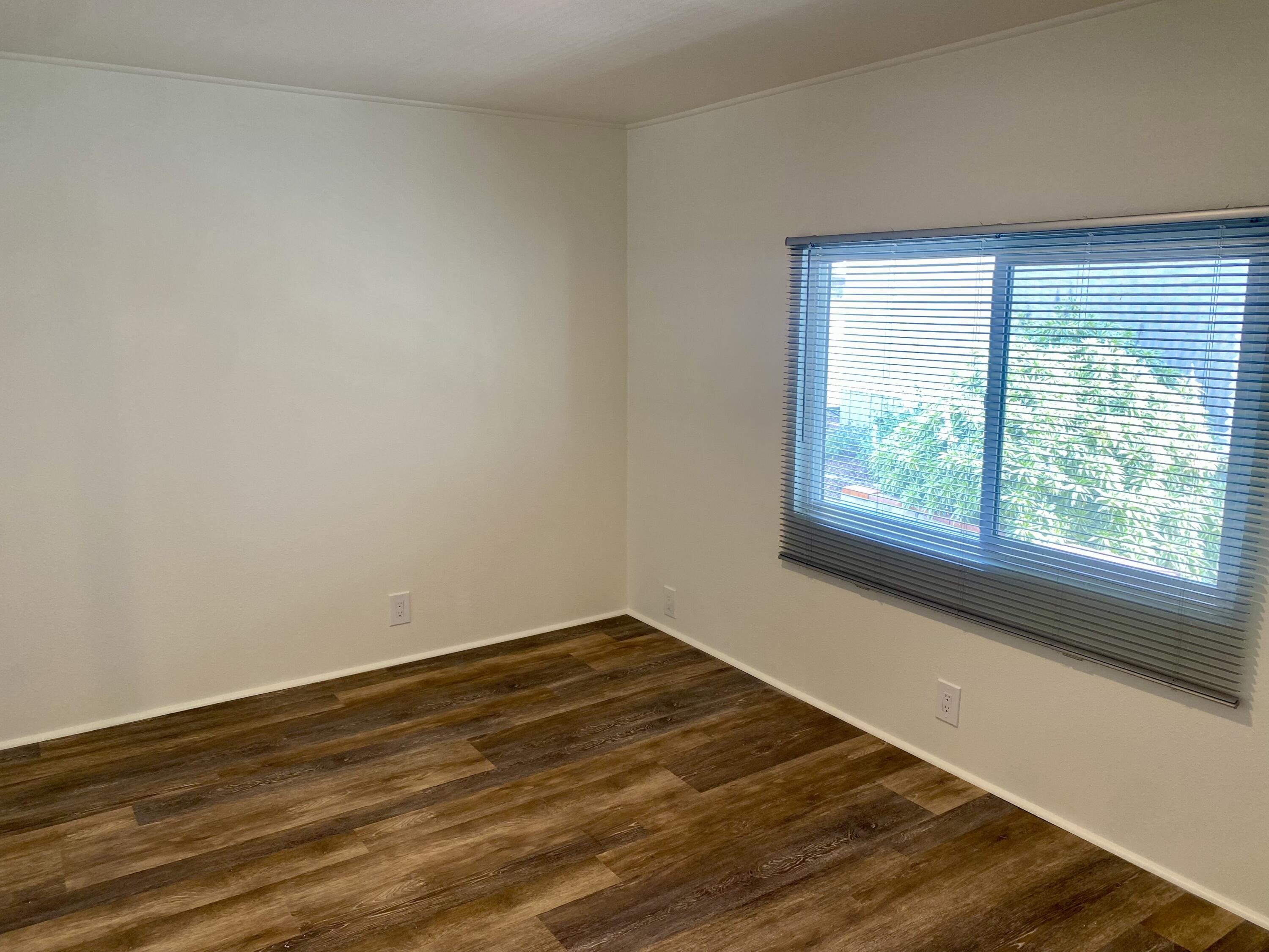 6480 Katherine Road, Unit 6 Simi Valley, CA 93063 - Photo 11 of 13 a view of an empty room with wooden floor and a window