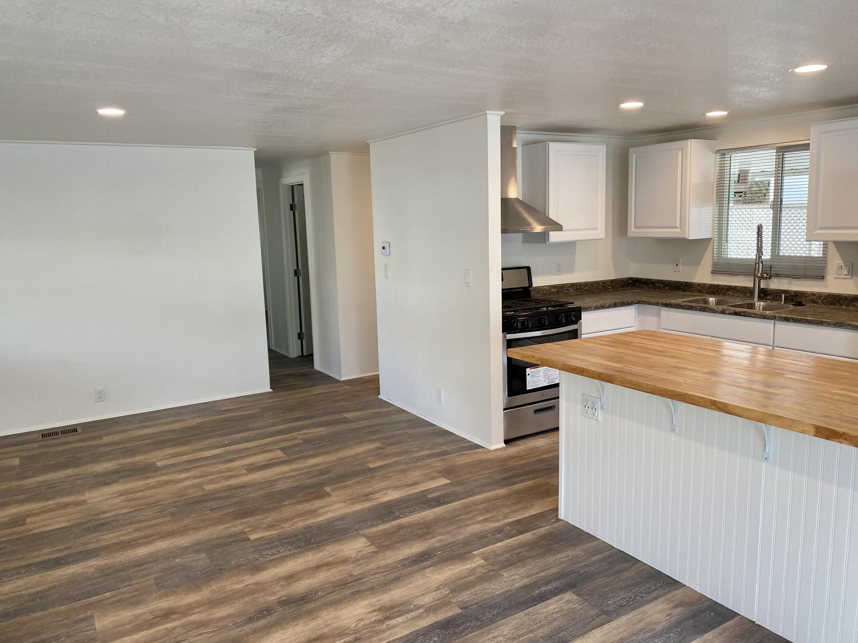 6480 Katherine Road, Unit 6 Simi Valley, CA 93063 - Photo 5 of 13 a view of a kitchen with kitchen island a sink wooden floor and stainless steel appliances