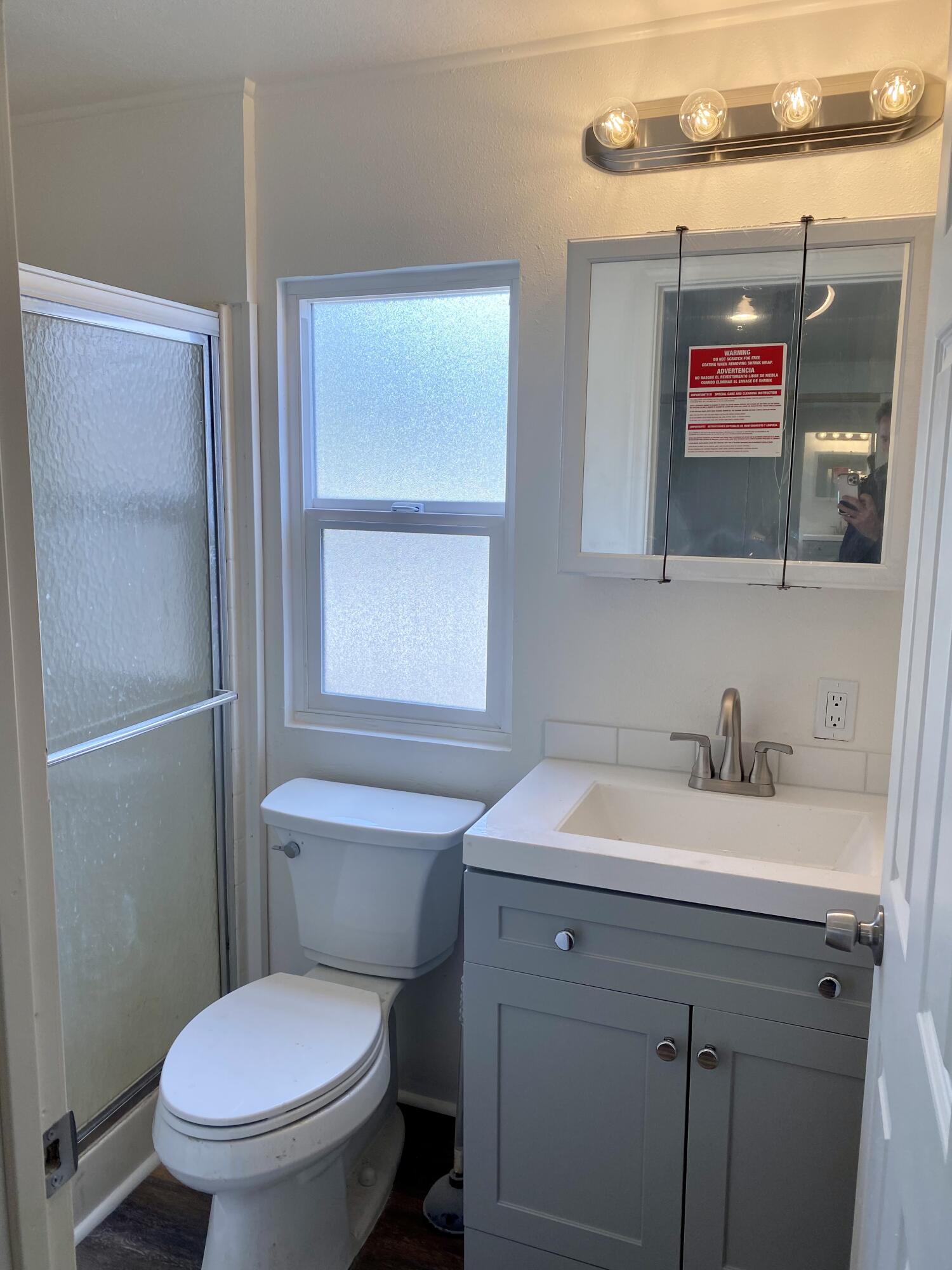 6480 Katherine Road, Unit 6 Simi Valley, CA 93063 - Photo 9 of 13 a bathroom with a toilet sink and mirror