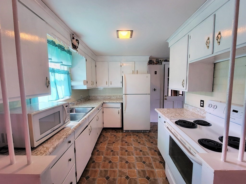 52 Ella Street Athol, MA 01331 - Photo 13 of 23 a kitchen with refrigerator a stove a sink a counter top space and cabinets