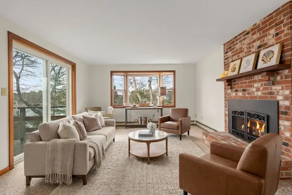 a living room with furniture a large window and a fireplace