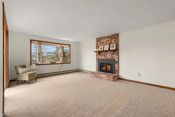 an empty room with windows fire place and fireplace