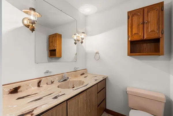 a bathroom with a sink a toilet and mirror