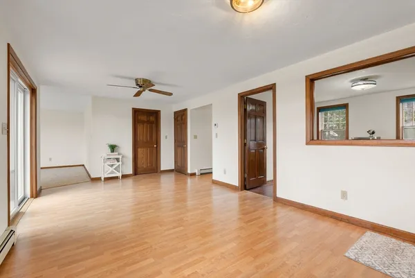 an empty room with window and wooden floor