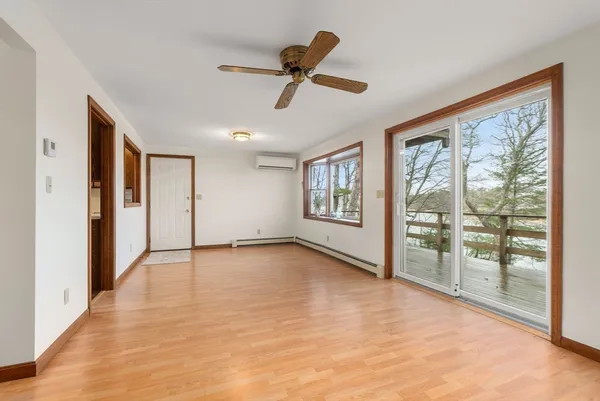 a view of an empty room with a window and wooden floor