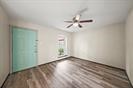 13726 Willie Melton Boulevard Kendleton, TX 77451 - Photo 4 of 12 an empty room with wooden floor fan and windows