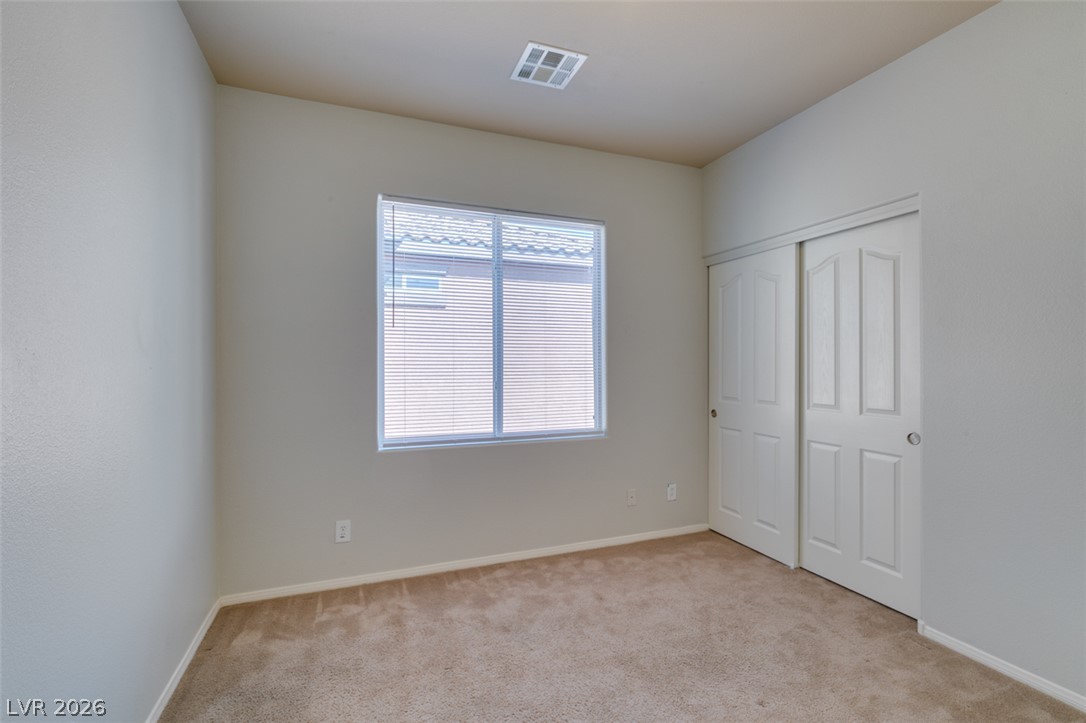 8937 Caledon Ridge Court Las Vegas, NV 89149 - Photo 29 of 43 A well-lit bedroom with soft carpeting awaits your personal touch.