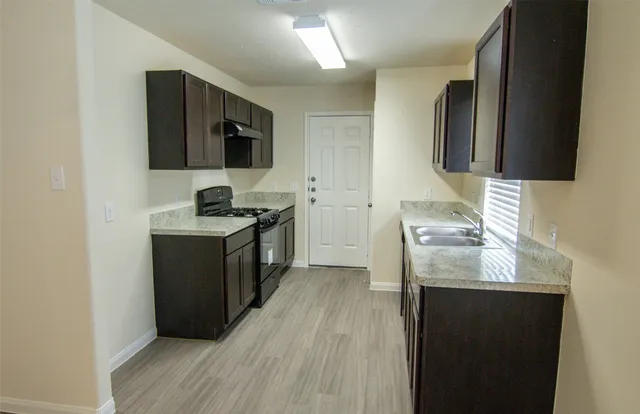 a kitchen with stainless steel appliances granite countertop a sink stove and refrigerator