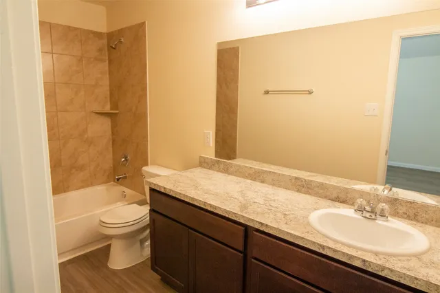 a bathroom with a granite countertop sink toilet and shower