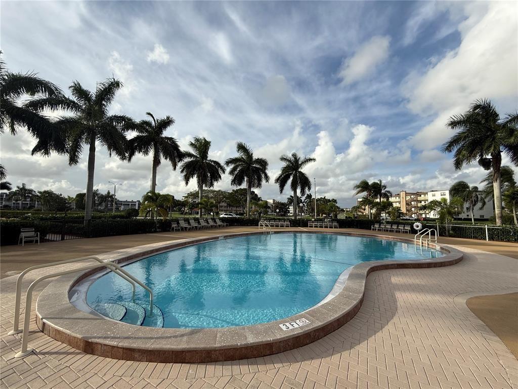 138 Fanshaw D, Unit D Boca Raton, FL 33434 - Photo 21 of 22 a view of a swimming pool with a terrace
