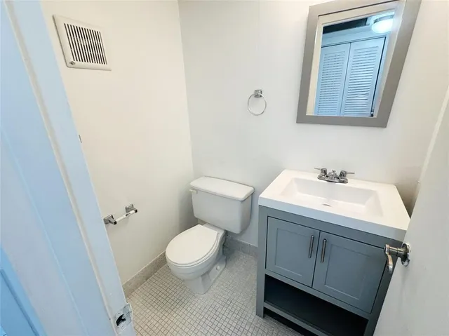 a bathroom with a sink toilet and a mirror
