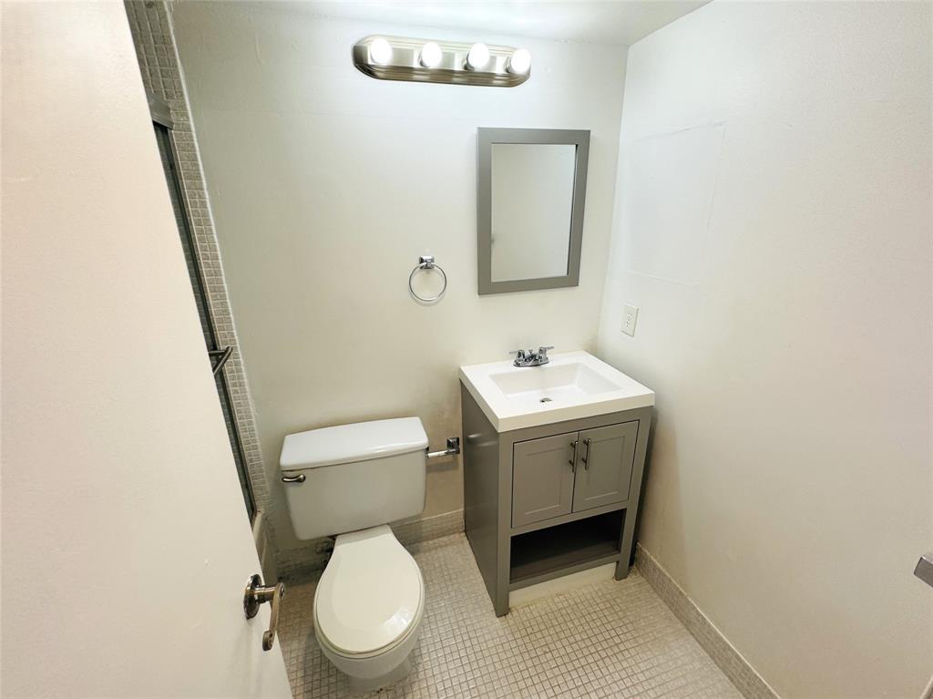 138 Fanshaw D, Unit D Boca Raton, FL 33434 - Photo 9 of 22 a bathroom with a toilet sink and mirror