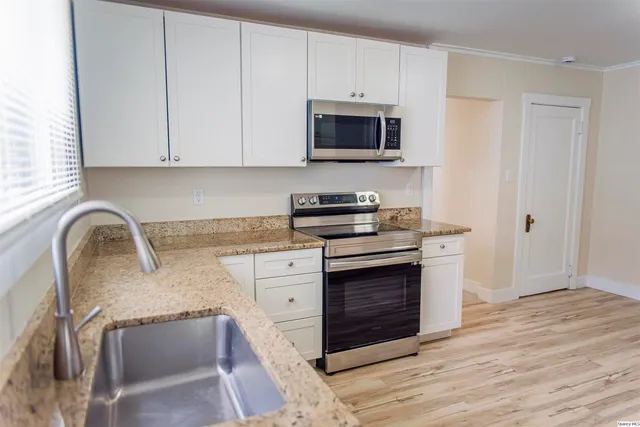 a kitchen with stainless steel appliances granite countertop a stove a microwave and a sink