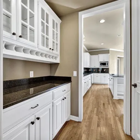 a view of a kitchen with cabinets and wooden floor