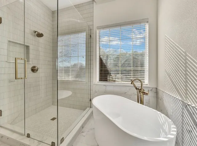 a bathroom with a bathtub and shower