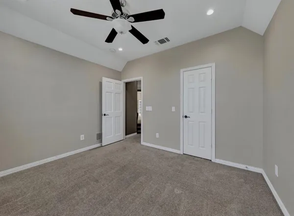 an empty room with ceiling fan and window