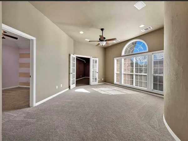 a view of an empty room with a window and a kitchen