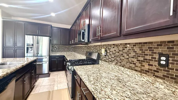 a kitchen with a stove a sink and a refrigerator