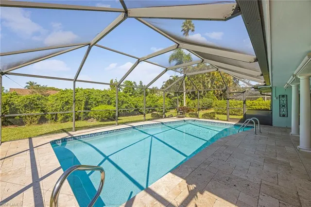 a view of a patio with table and chairs under an umbrella