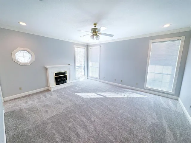 an empty room with windows and ceiling fan