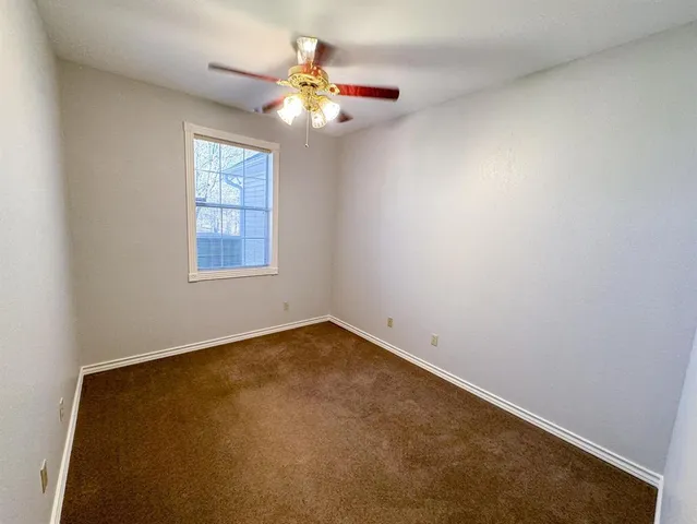 an empty room with a chandelier fan