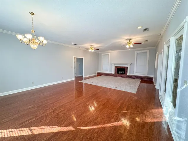 a view of a livingroom with a ceiling fan window and wooden floor
