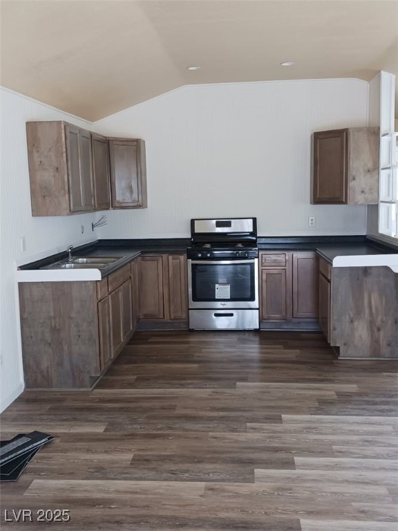 1208 Broadway Street Goldfield, NV 89013 - Photo 16 of 23 Kitchen featuring dark countertops, dark wood-type flooring, stainless steel range with gas stovetop, vaulted ceiling, and a sink