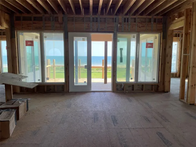 a view of a room with large windows and couch