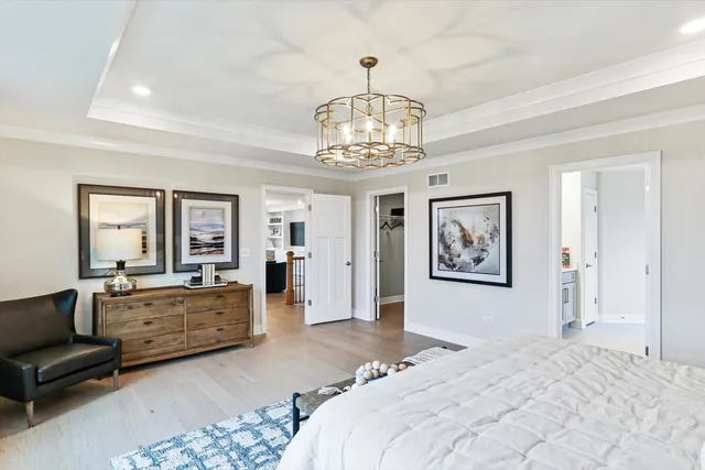 a bedroom with a large bed and a chandelier