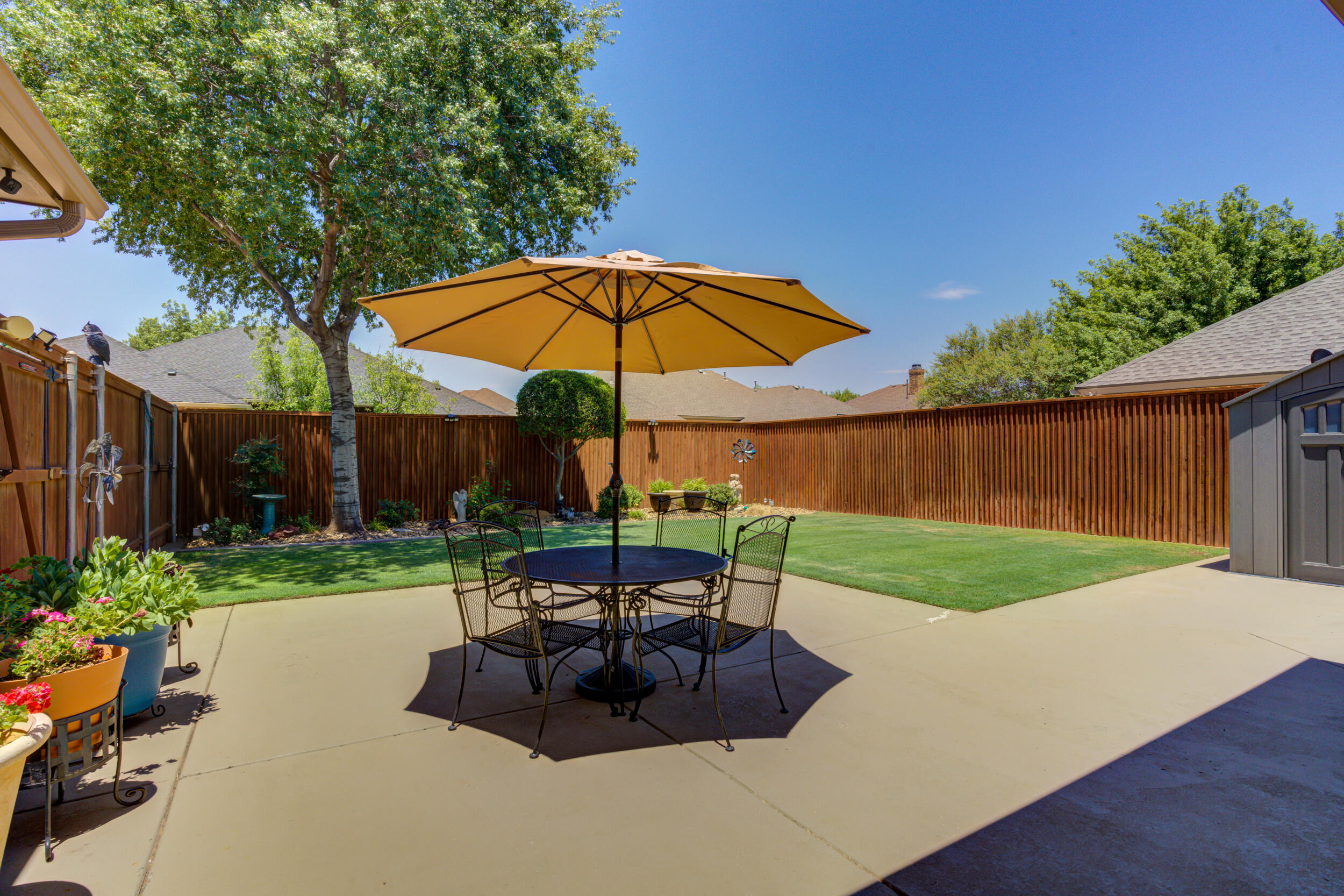 6008 89th Street Lubbock, TX 79424 - Photo 53 of 61 a view of a backyard with table and chairs under an umbrella