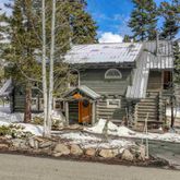 a front view of a house with a large tree