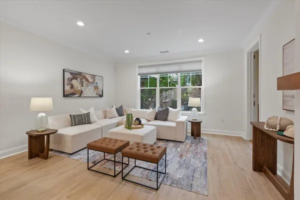 a living room with furniture and a view of kitchen