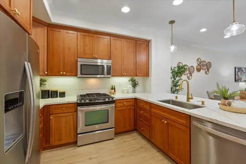 a kitchen with stainless steel appliances granite countertop a refrigerator stove and sink