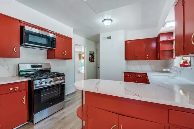 a kitchen with stainless steel appliances granite countertop a stove and a microwave
