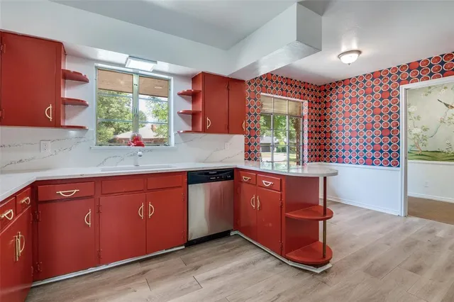 a kitchen with stainless steel appliances granite countertop wooden cabinets a sink and a large window