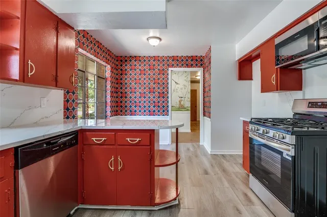 a kitchen with stainless steel appliances granite countertop a stove a sink and a refrigerator
