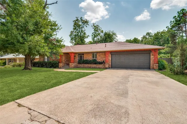 a front view of a house with a yard and trees