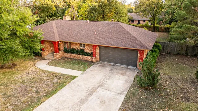 a aerial view of a house with a yard and large tree