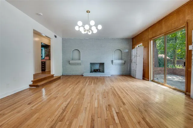 a view of empty room with a fireplace and wooden floor